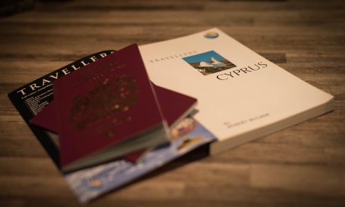 Passport and travel guide on table planning a holiday